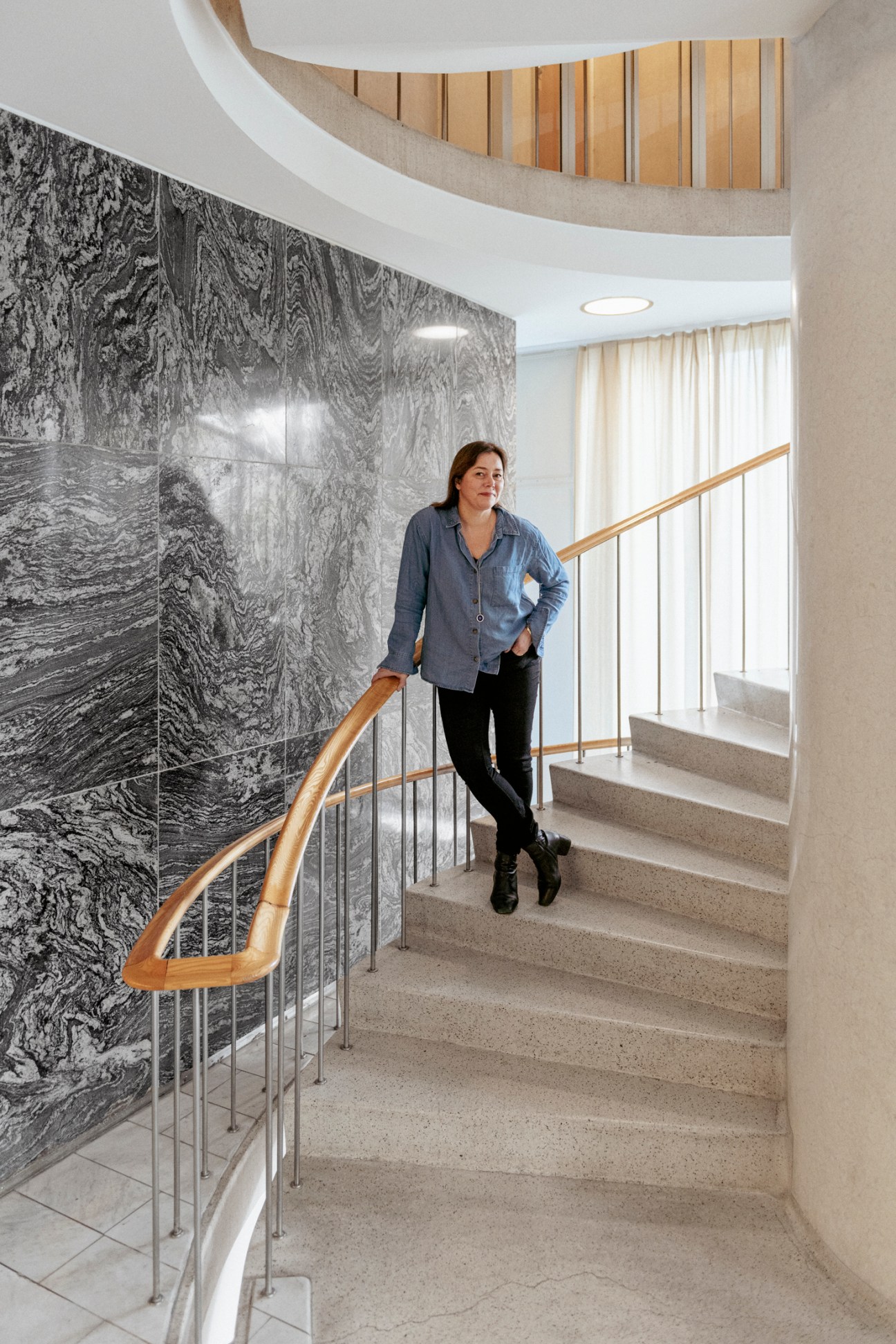 Marianne Furevold-Boland, head of drama at NRK, standing on a staircase in a modern building.