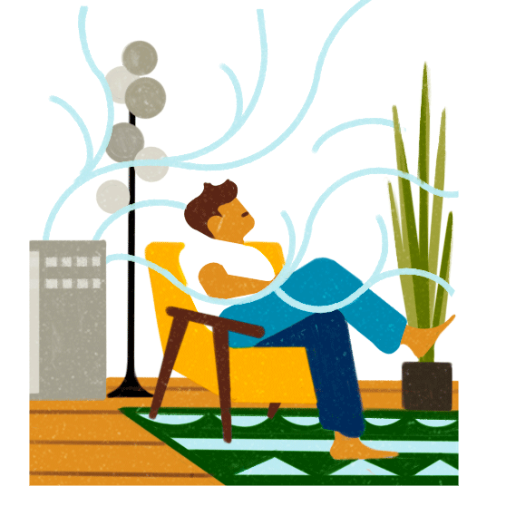 Person relaxing in yellow chair with air purifier and plant nearby