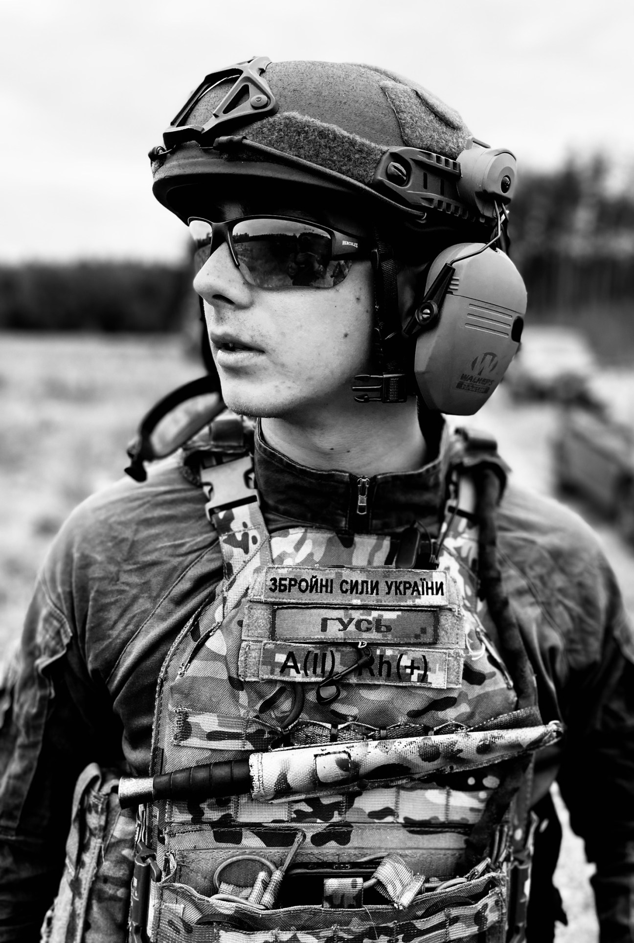 Ukrainian soldier 'Goose' wearing military helmet, thermal imaging goggles, and body armor with Ukrainian insignia.