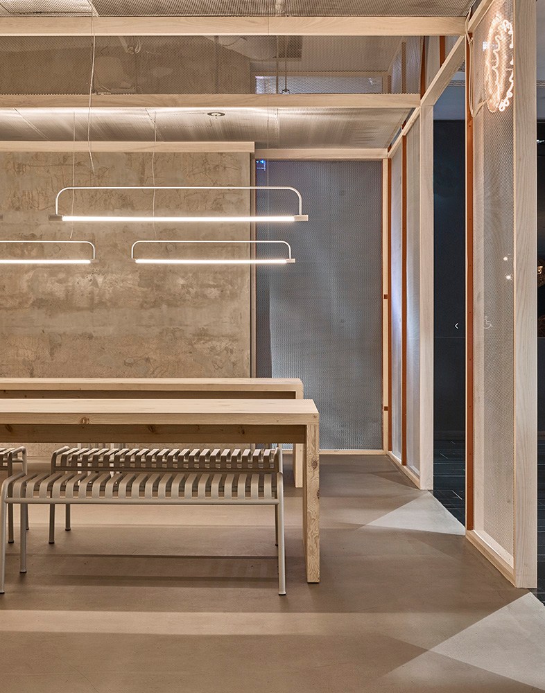 Modern cinema interior with wooden fixtures, pendant lighting, and glass-walled spaces