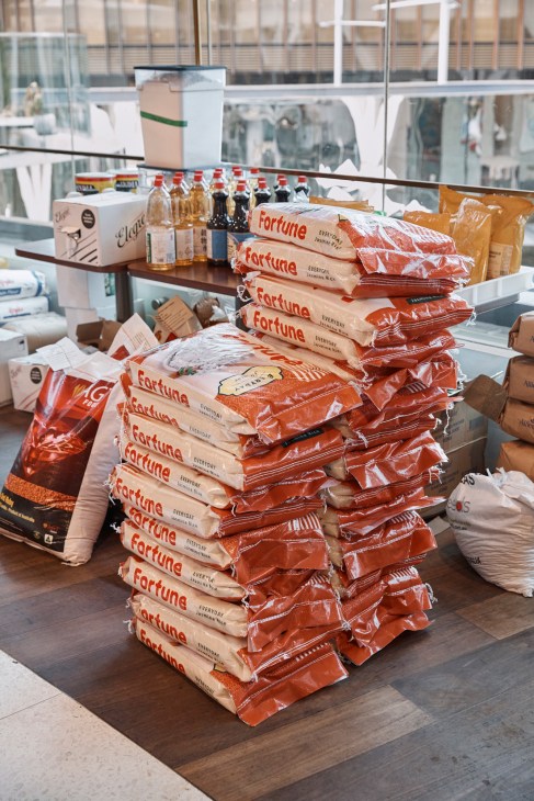Stacked Fortune brand packaged ingredients and bottles of sauce displayed on a shelf in a bright kitchen.