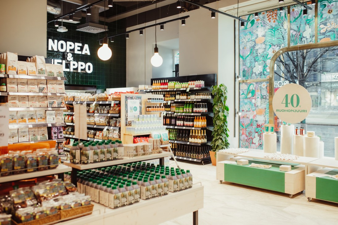 Ruohonjuuri food store interior with modern shelving, pendant lights, and botanical wallpaper in Helsinki