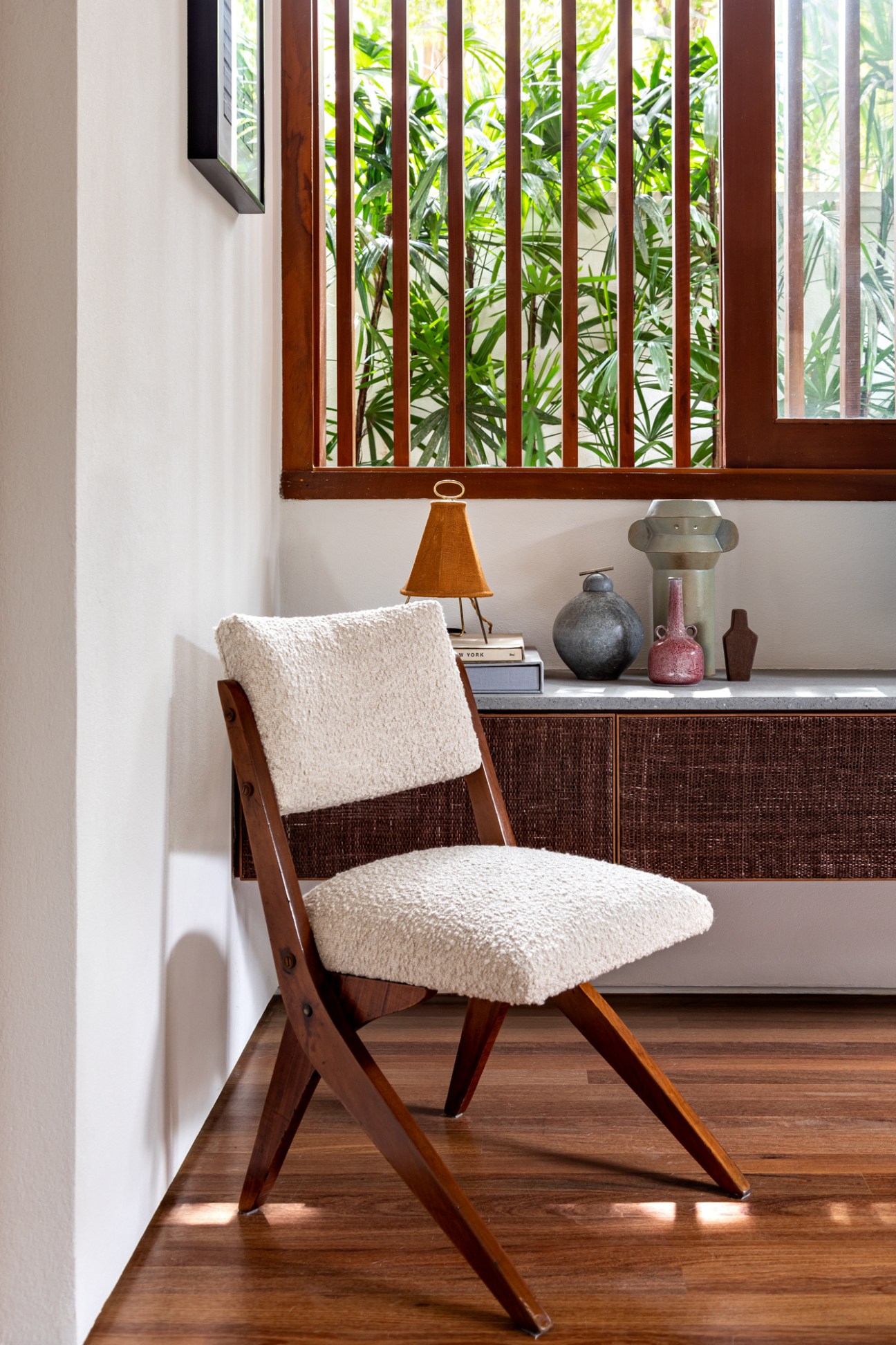 Mid-century wooden chair with white fluffy upholstery on seat and backrest in modern interior
