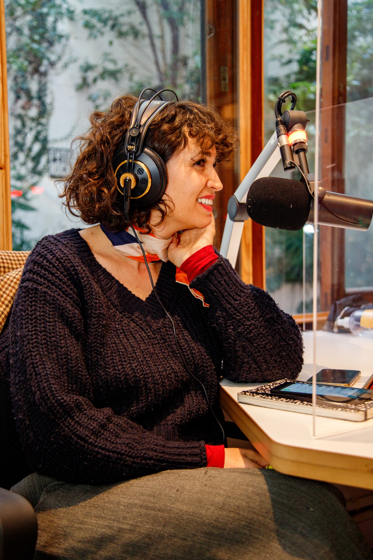 Julia Mengolini, co-founder of digital radio station Futuröck, speaking into a microphone while wearing headphones in a studio.