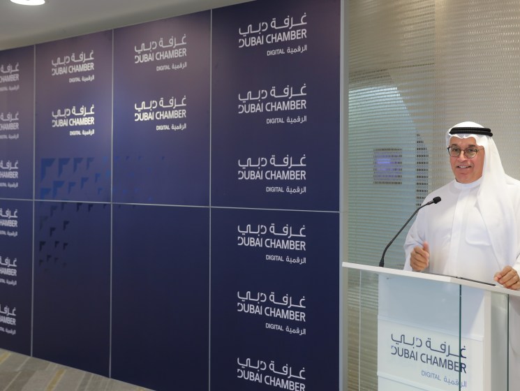 Ahmad Bin Byat speaking at a podium during a Dubai Chamber of Digital Economy event.