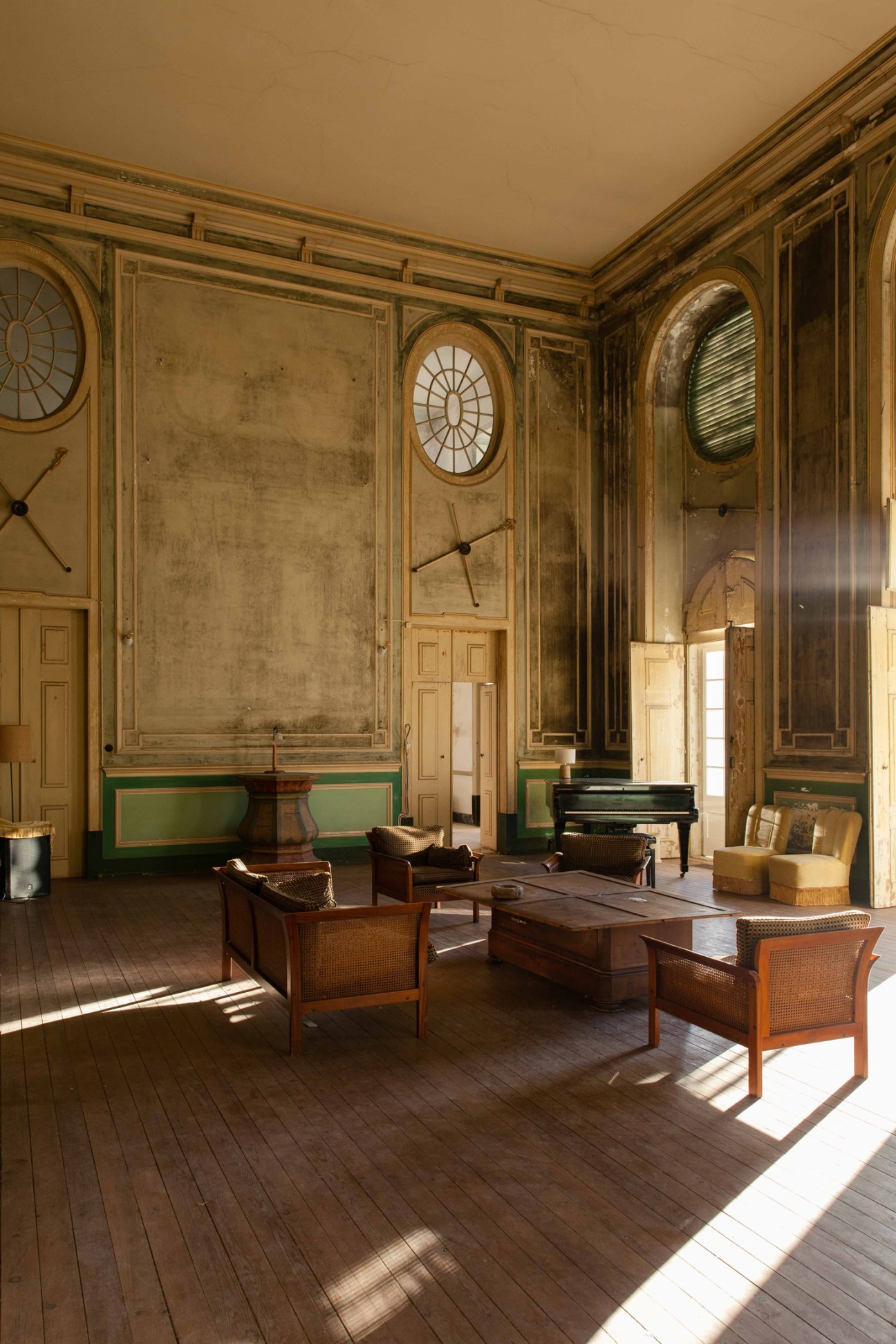 Grand interior room with ornate architectural details, wicker furniture, and classical design elements