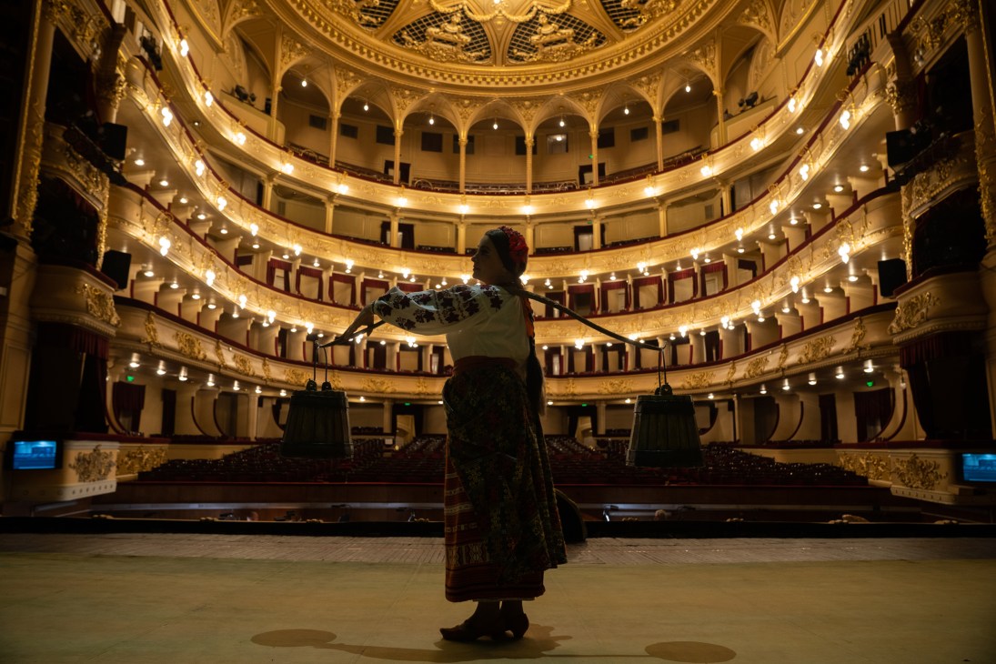 Performer on stage at National Opera of Ukraine in Kyiv with ornate tiered seating and golden interior architecture