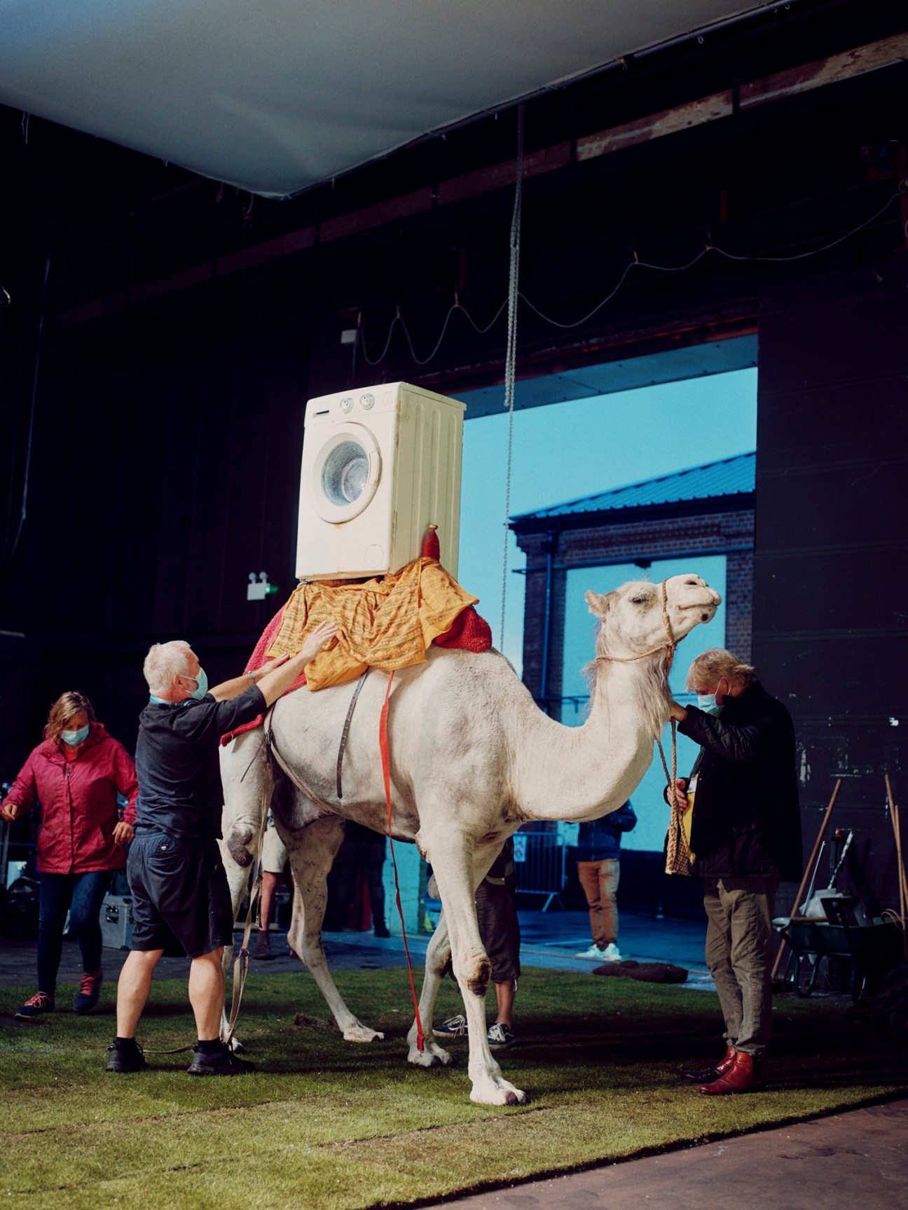 A white washing machine character named Hank positioned on a camel