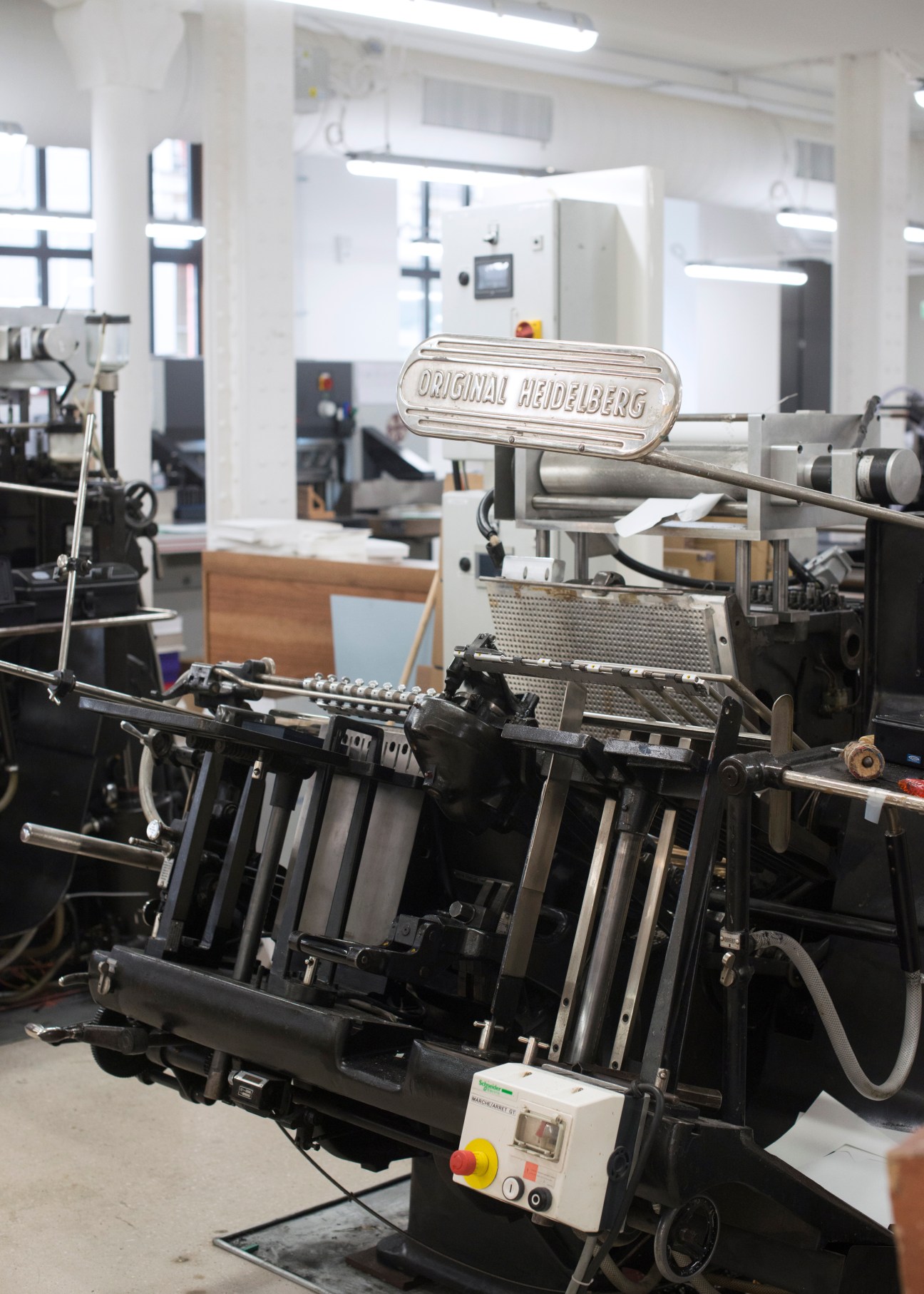 Close-up of vintage letterpress machine showing mechanical details and typography elements