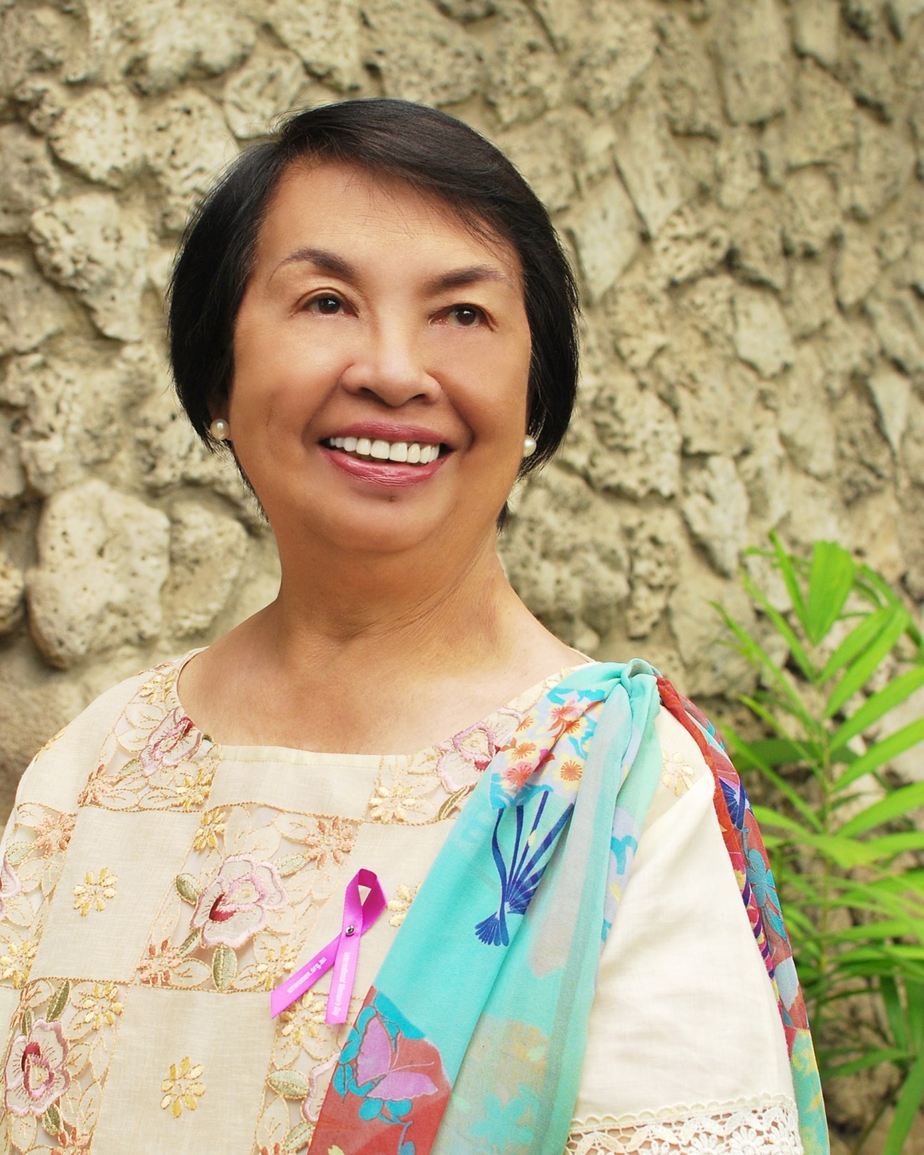 Portrait of Irene Santiago, an 82-year-old Philippine peacemaker and Nobel Peace Prize nominee, smiling against a textured wall.
