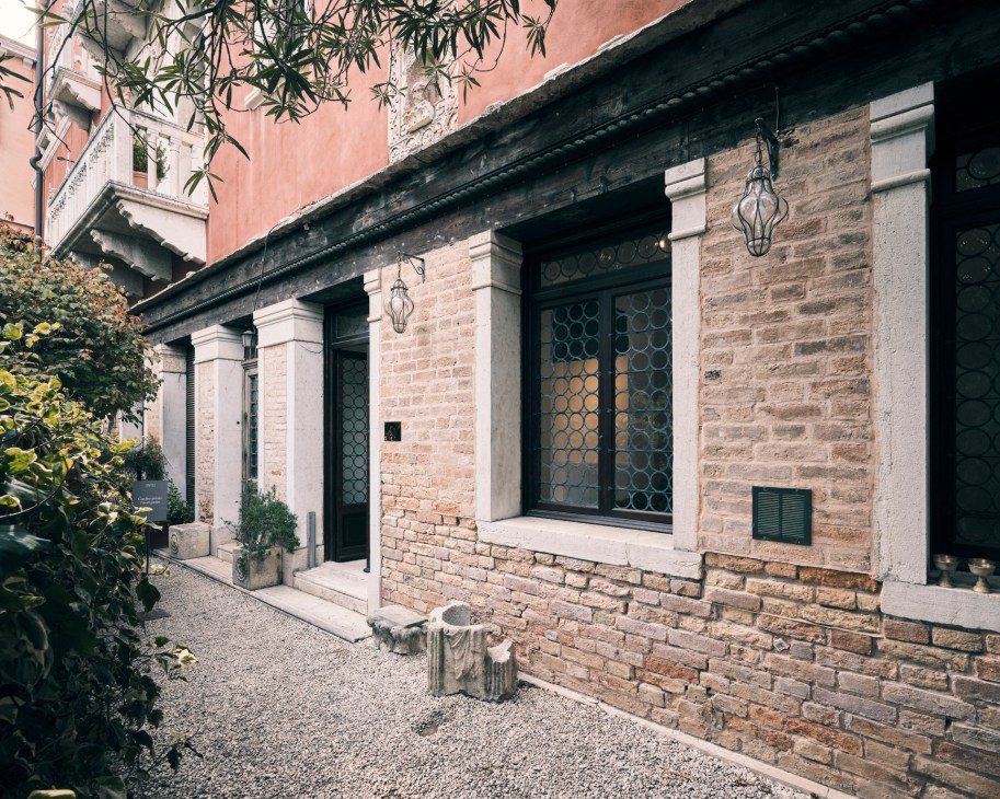 Exterior view of In'ei gallery in Venice showing brick facade with decorative lanterns and geometric patterned doors.