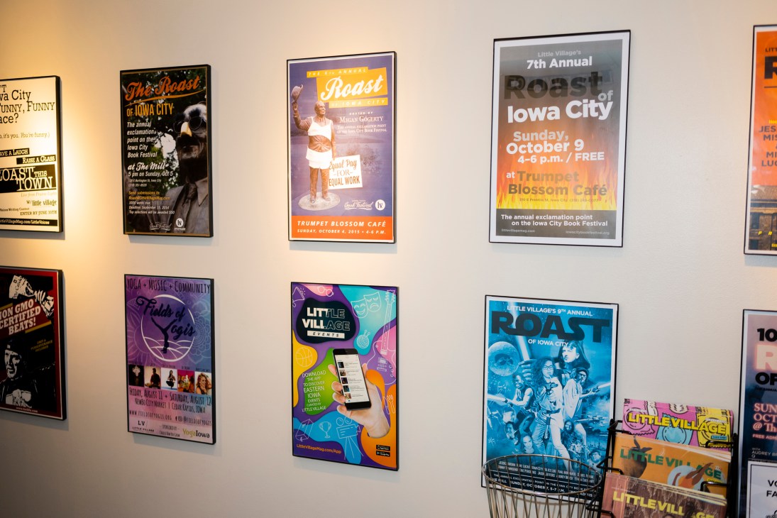 Wall display of event posters including Little Village Roast of Iowa City announcements and music event flyers.