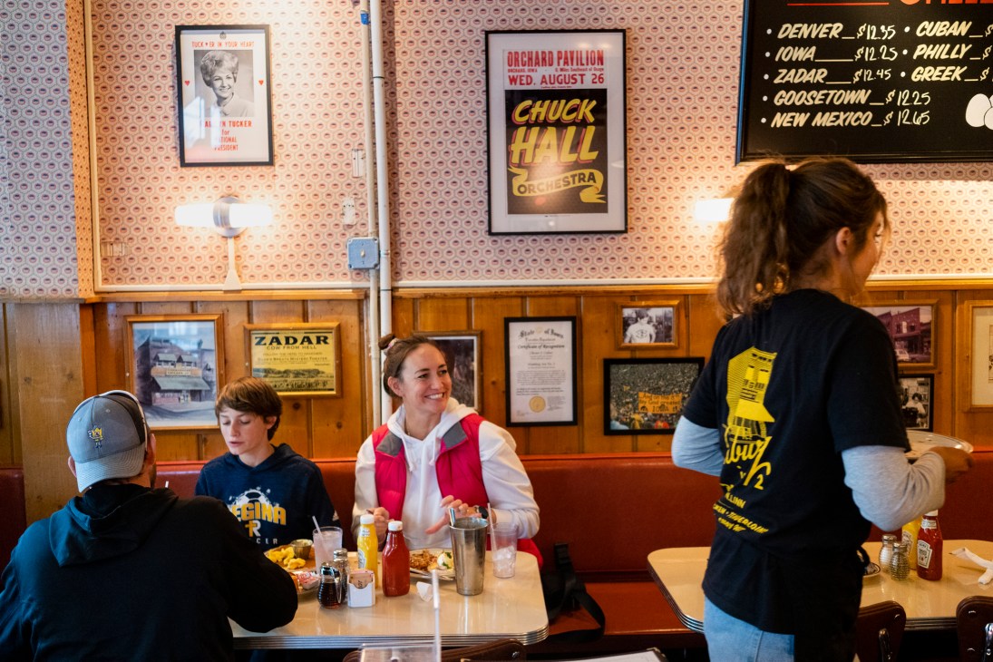 Diners at Hamburg Inn No 2, a retro diner in Iowa City decorated with vintage posters and memorabilia on wood-paneled walls.