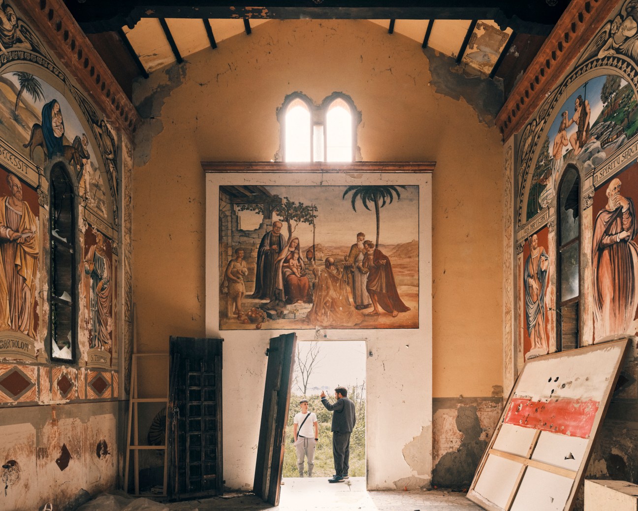 Paolo Rosso with a guest outside a partially overgrown church