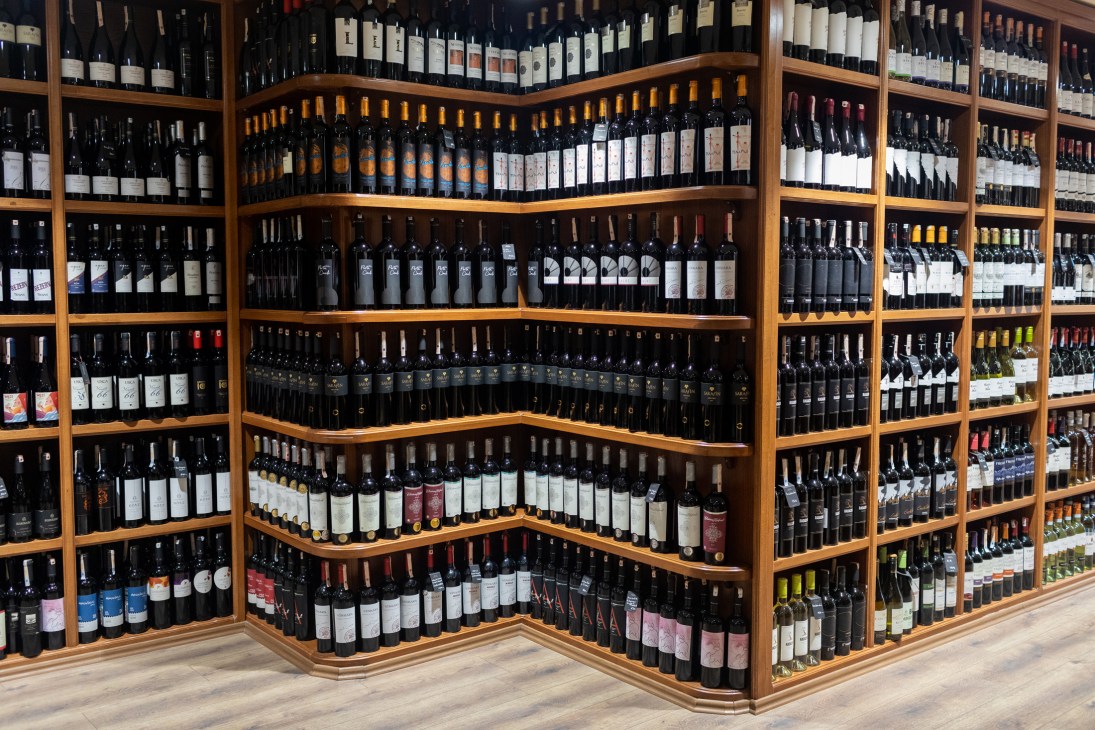 Wine bottles displayed on wooden shelves in a wine shop