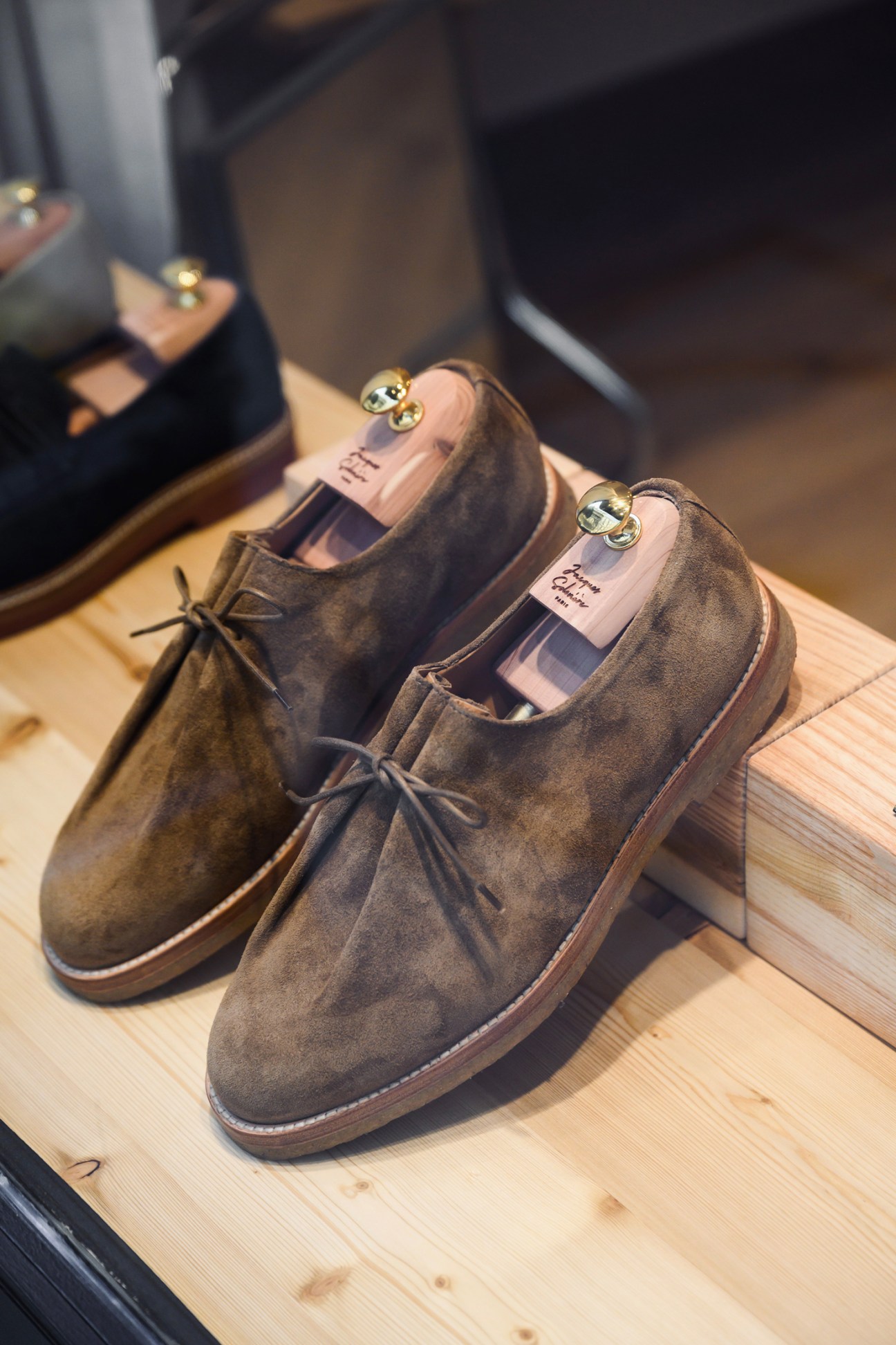 Display of Jacques Solovière autumn footwear collection featuring suede desert boots with wooden shoe trees