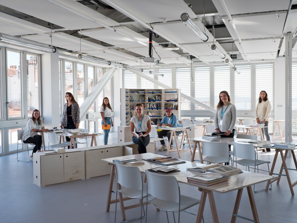 Students and instructors in a bright, modern workshop space at Camondo Méditerranée with modular furniture and large windows.