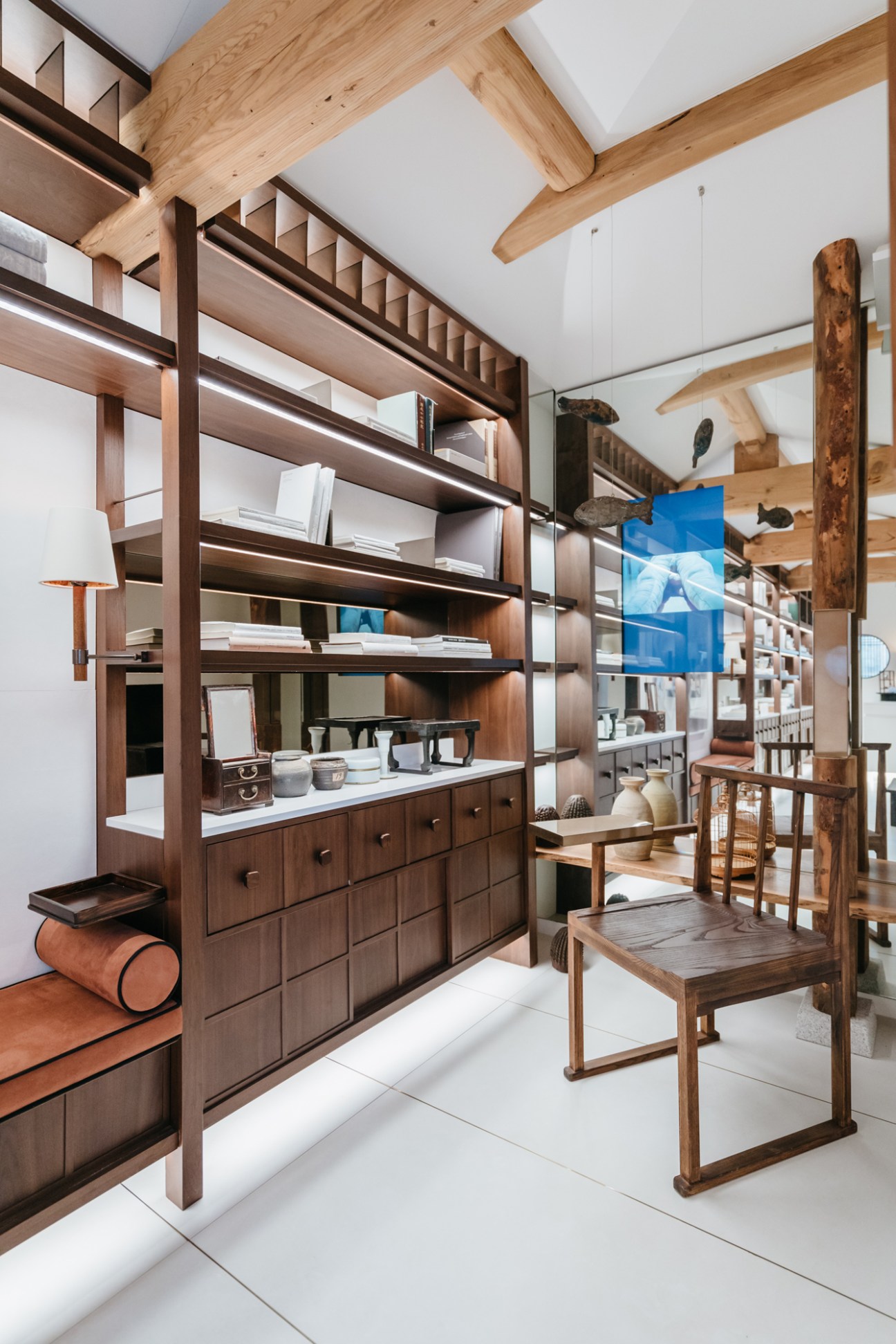Interior showing wooden shelving system with ceramics, exposed beams, and traditional Korean wooden chair