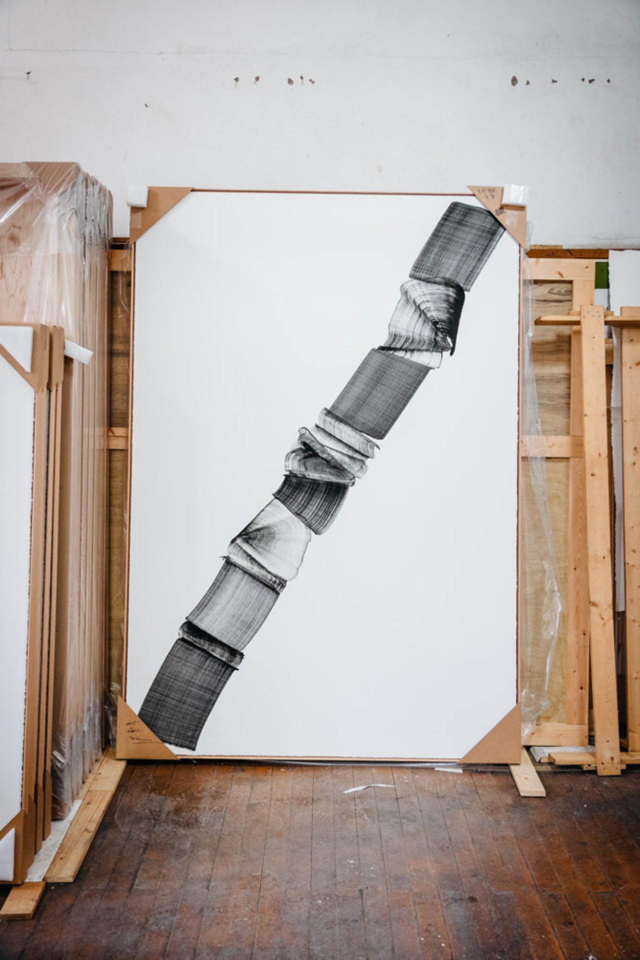 Abstract artwork featuring vertical striped patterns in black and white with wrapped textile elements on canvas.