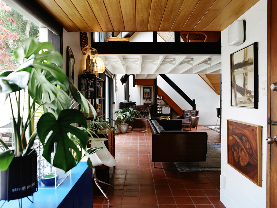 Interior view of the B Jones house showing living room with timber ceiling, exposed beams, and mezzanine level