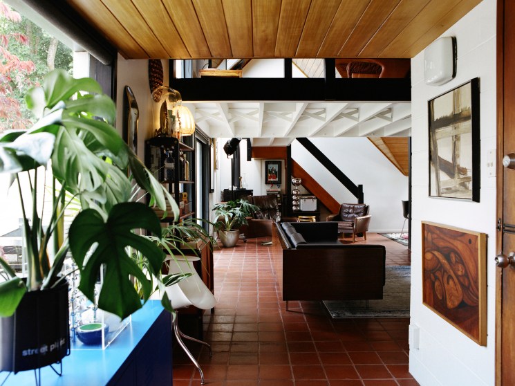 Interior view of the B Jones house showing living room with timber ceiling, exposed beams, and mezzanine level