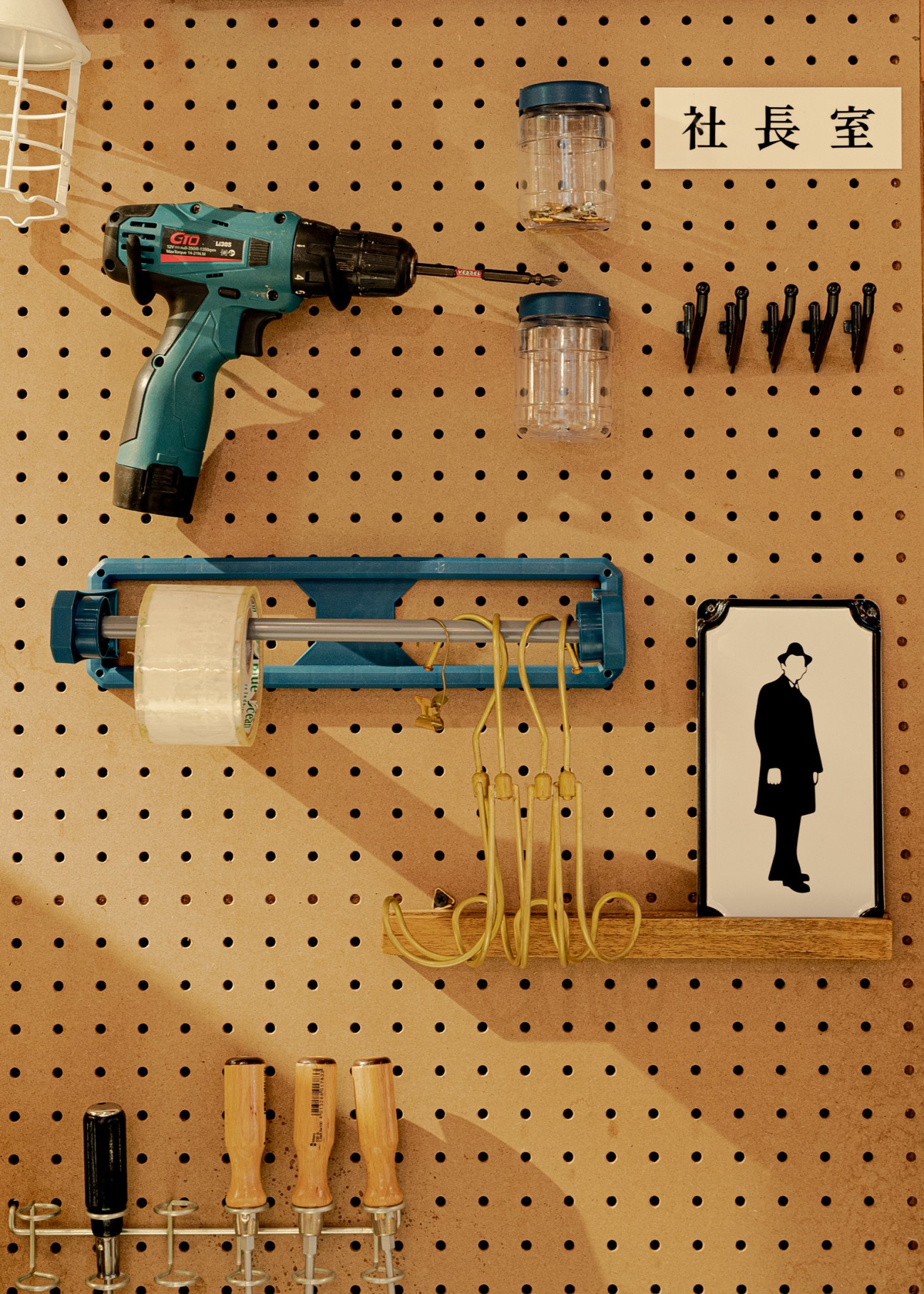Organized pegboard wall displaying various tools, containers, and hardware items in a shop setting