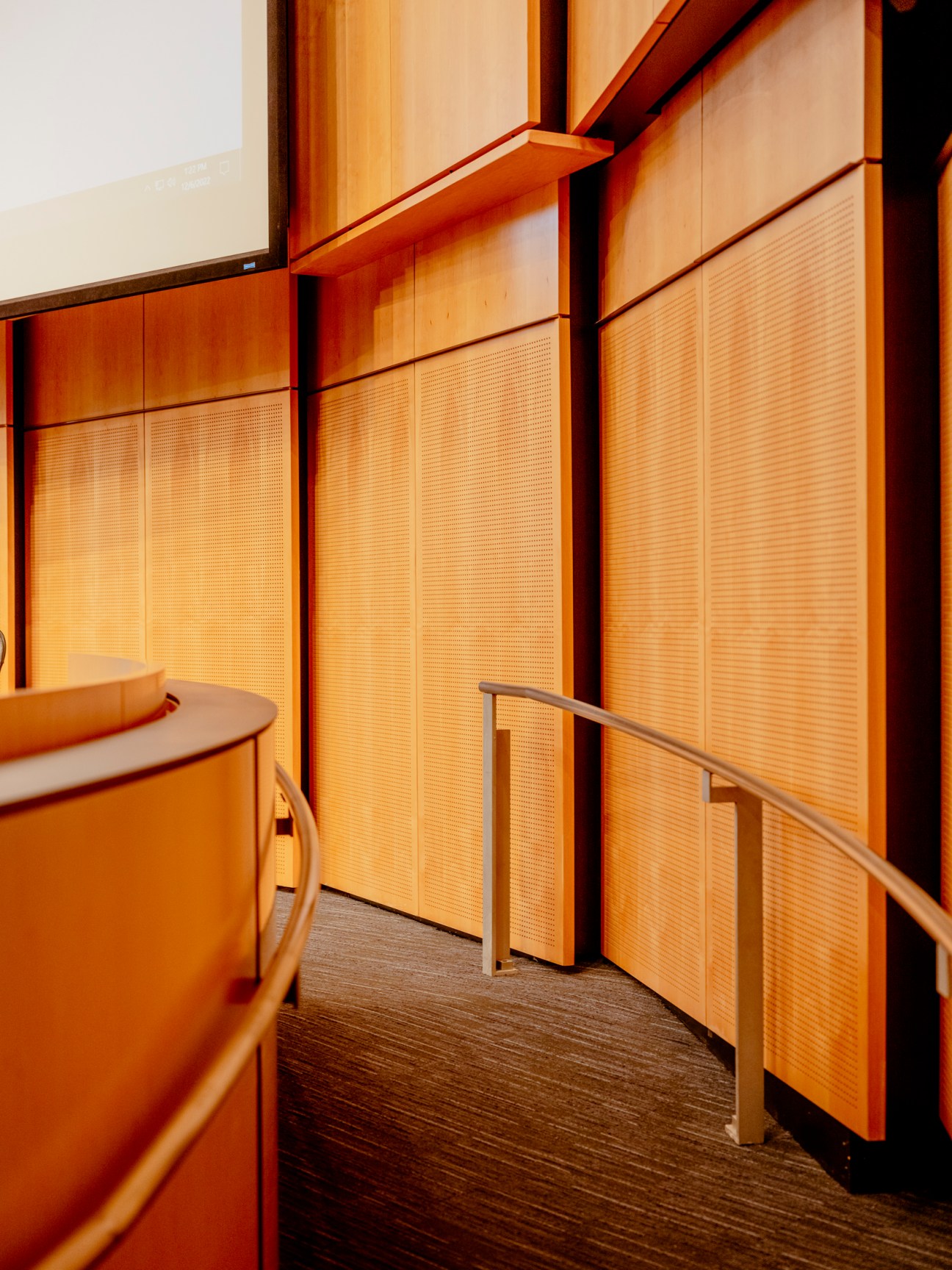 Wide interior view of person walking towards the council dais in Seattle City Hall chambers