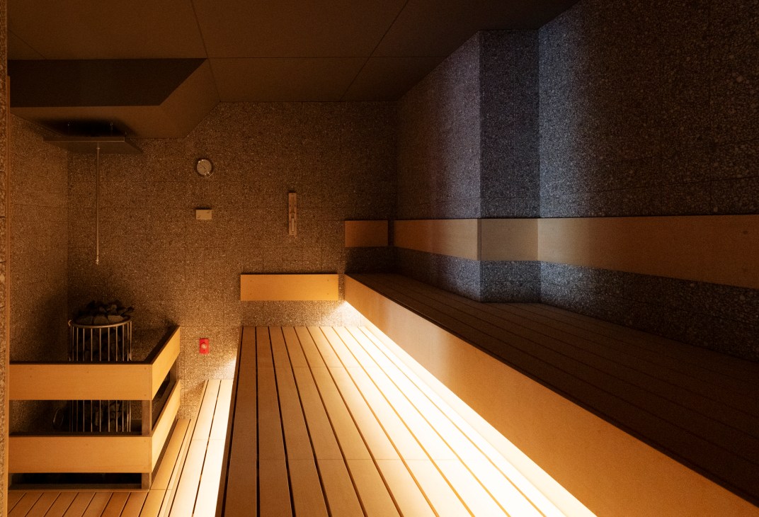 Interior of cypress-wood sauna with wooden benches and traditional Japanese design elements