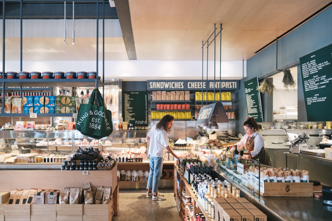 Modern Italian deli interior with colorful product displays and customers browsing King & Godfree
