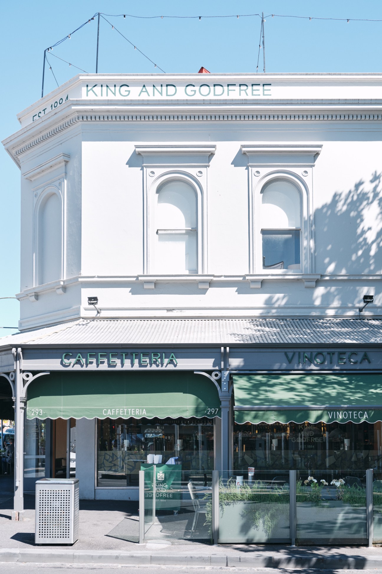 Historic white corner building with classical architecture featuring King and Godfree signage and ground floor retail spaces