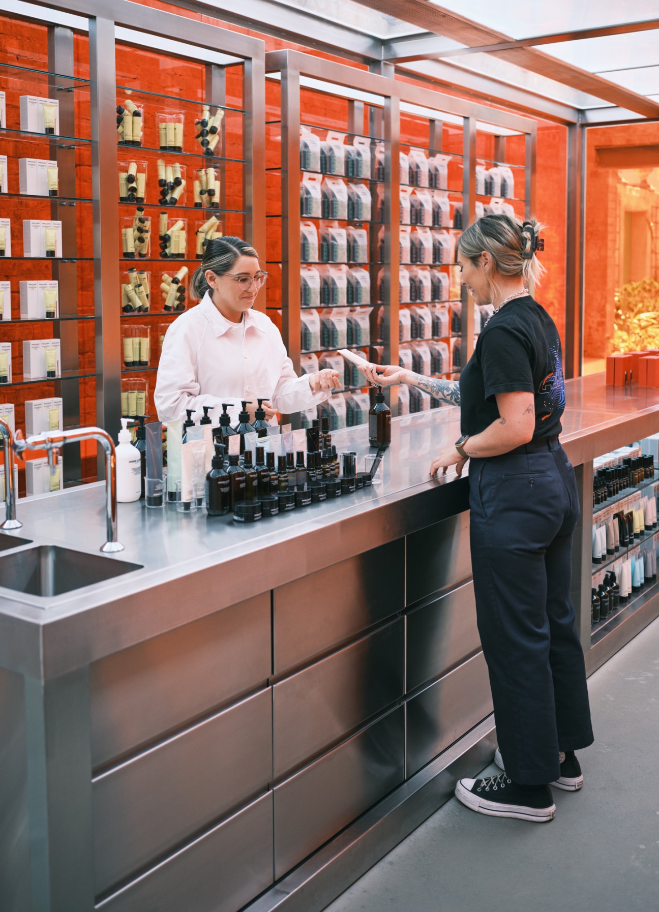 Two women shopping at Grown Alchemist skincare store with product displays and shelving