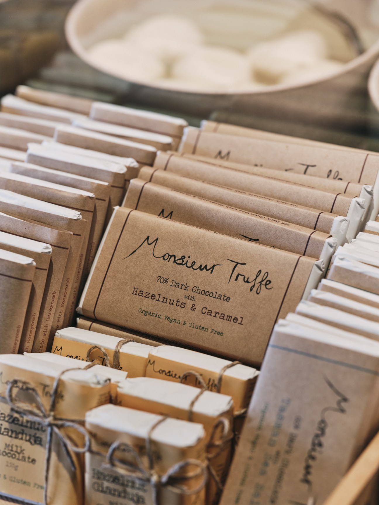 Monsieur Truffe chocolate bars with brown kraft paper packaging displayed in a basket