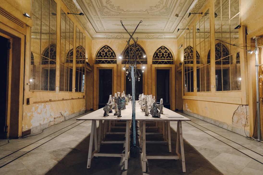 Ceramic artwork with small flame-like sculptural elements arranged on white table surface
