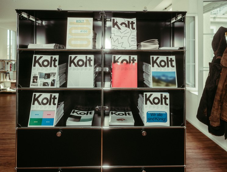 Shelves displaying multiple issues of Kolt magazine in a retail display.