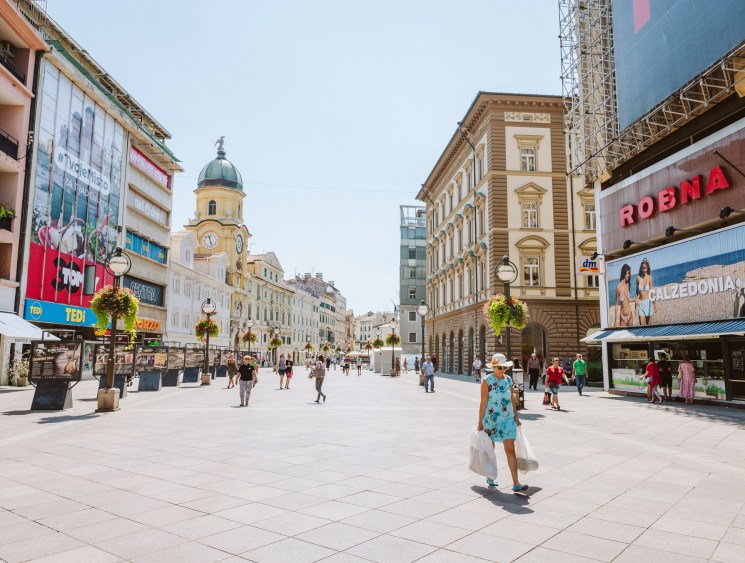Pedestrians walking along the Korzo pedestrian street lined with historic Habsburg-era buildings and modern shops