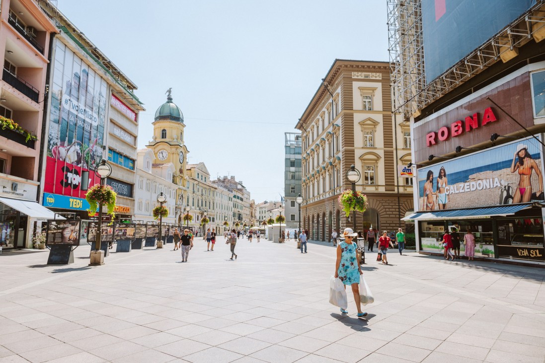 Pedestrians walking along the Korzo pedestrian street lined with historic Habsburg-era buildings and modern shops