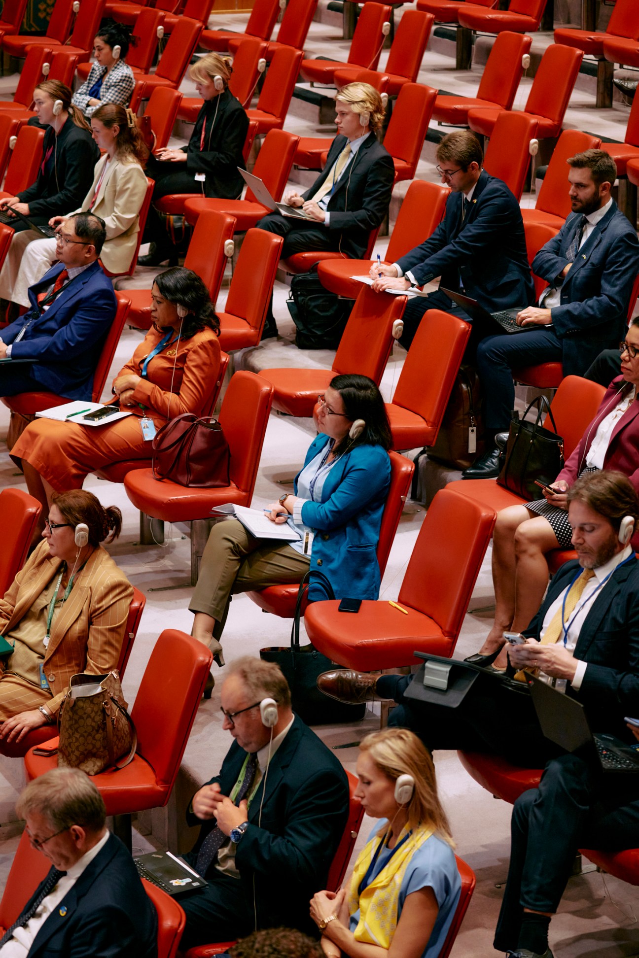 Diplomats and observers seated in red chairs at the UN Security Council chamber.