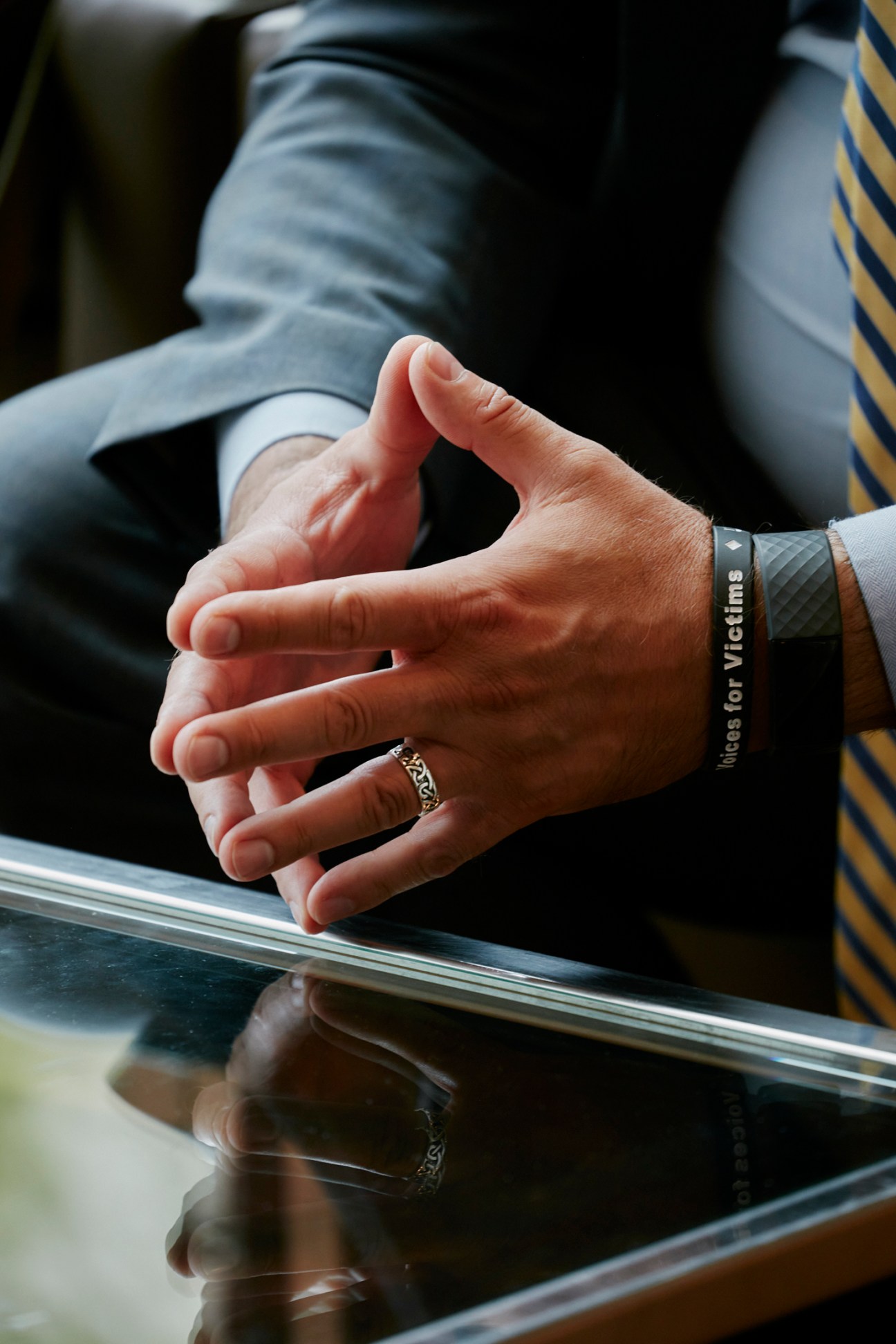 Hands clasped on a desk during a UN Security Council meeting.