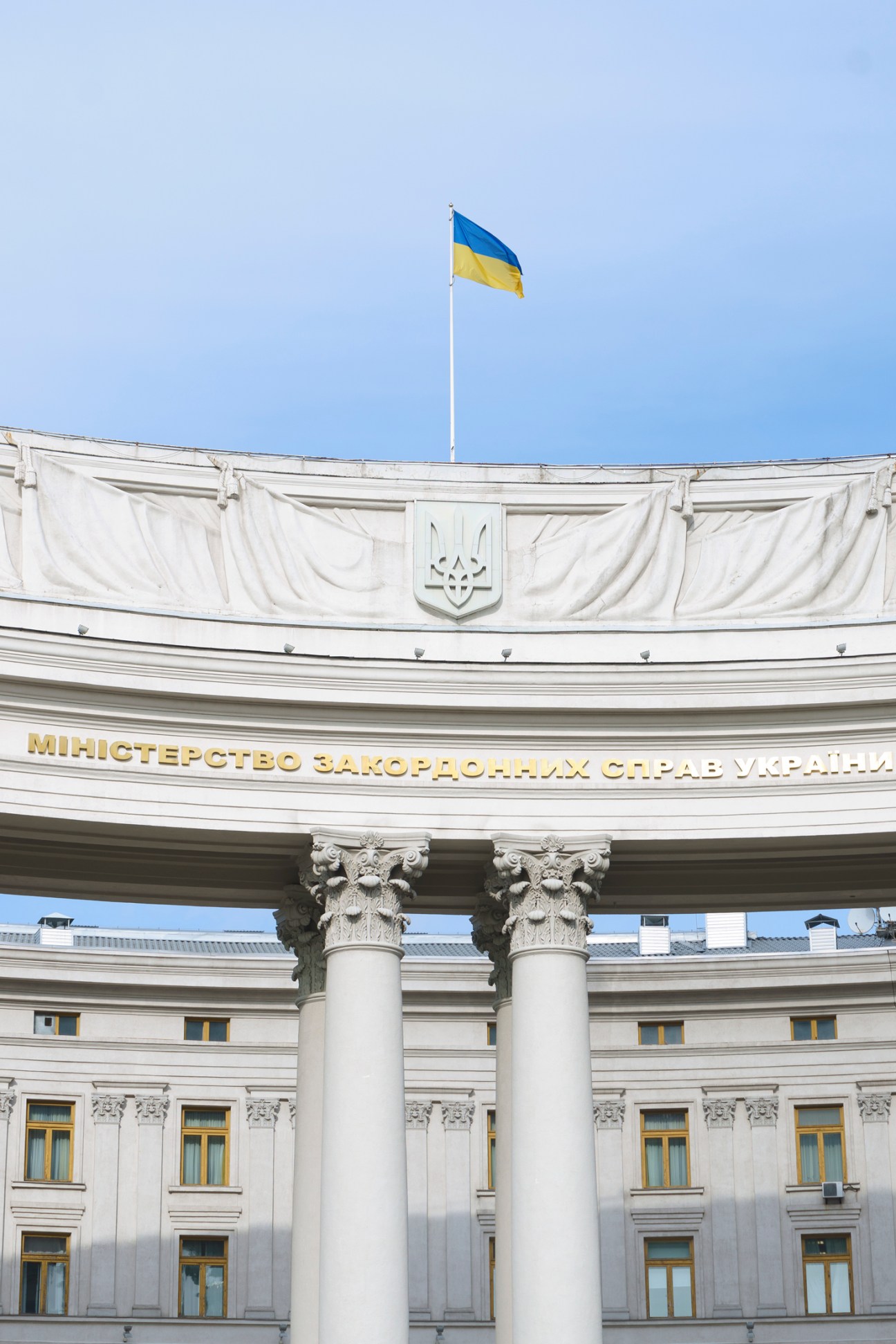 The exterior of Kyiv's Ministry of Foreign Affairs building with classical columns and Ukrainian flag