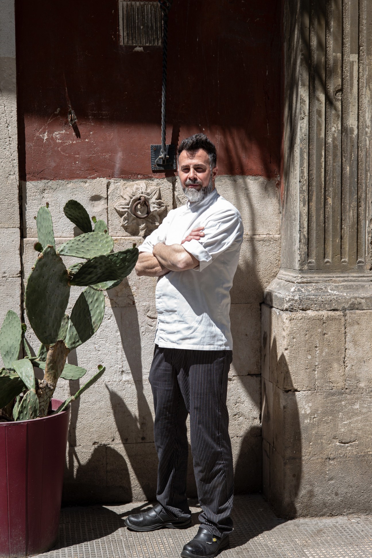 A chef in a white chef's coat stands at a restaurant counter.