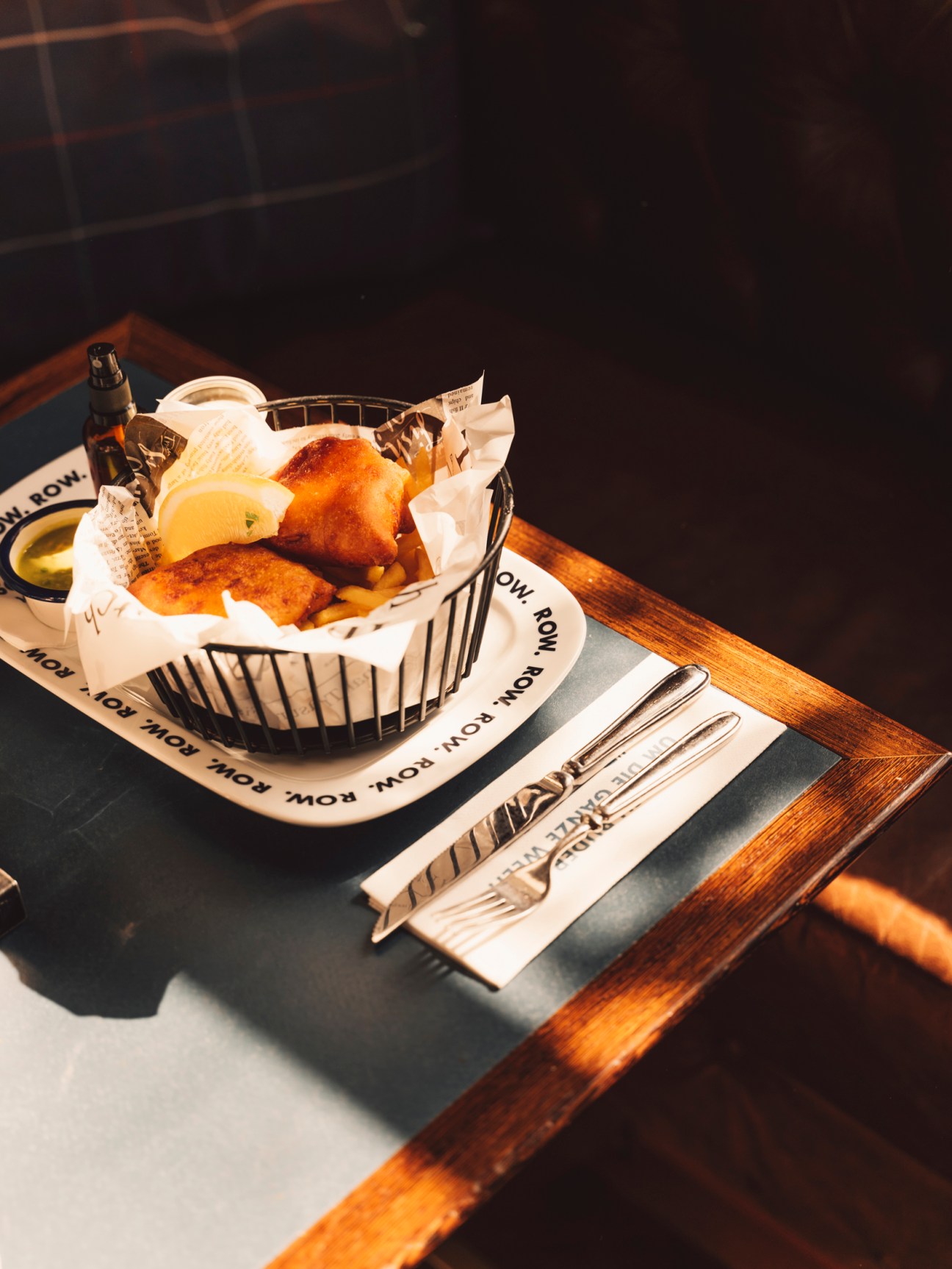 Basket of bread and pastries with wooden utensils on restaurant table
