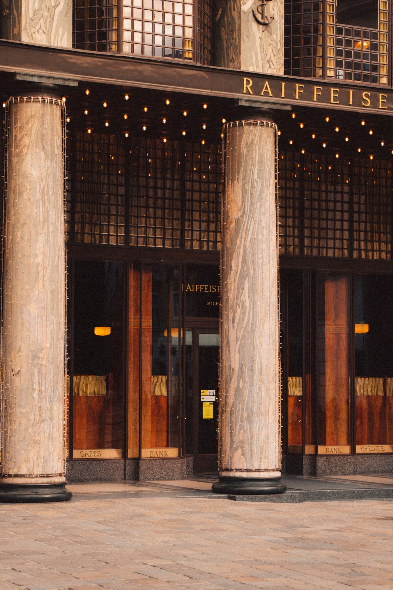 Classical bank building facade with marble columns, ornate windows, and Raiffeisen signage