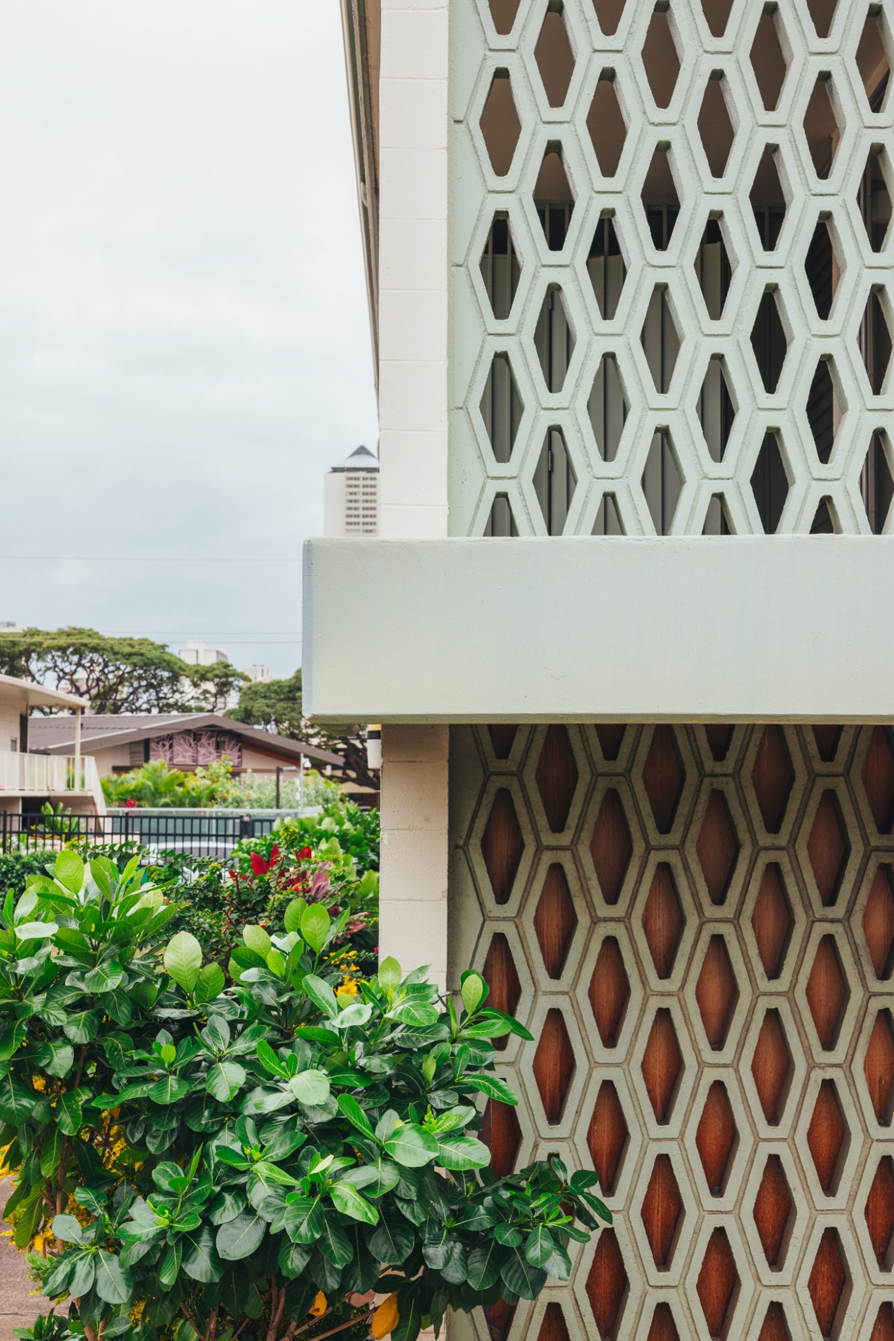 Modernist building facade featuring decorative concrete breeze blocks with diamond-shaped perforations and lattice patterns