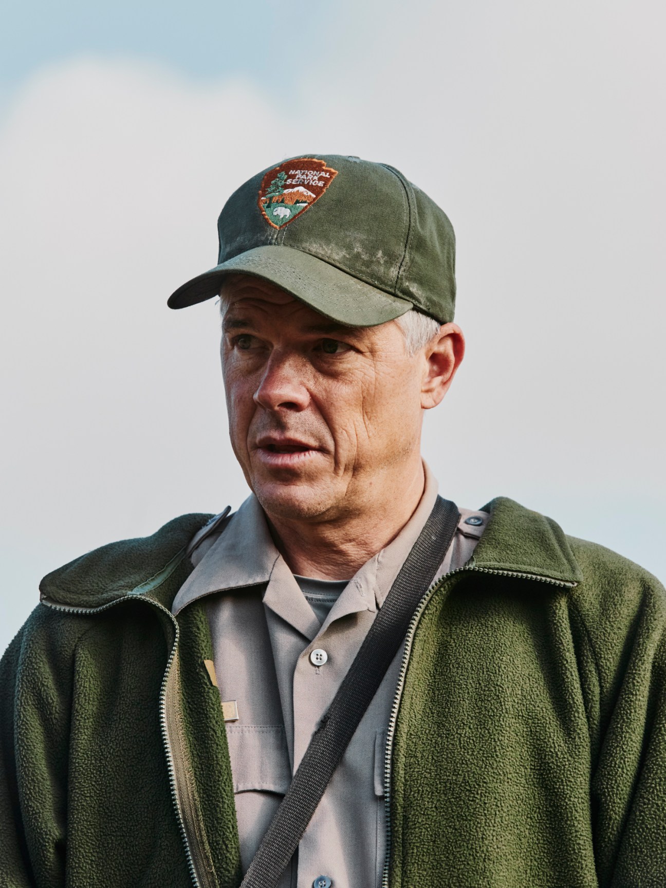 Biologist Jeff Sikich wearing National Park Service cap and green fleece jacket outdoors