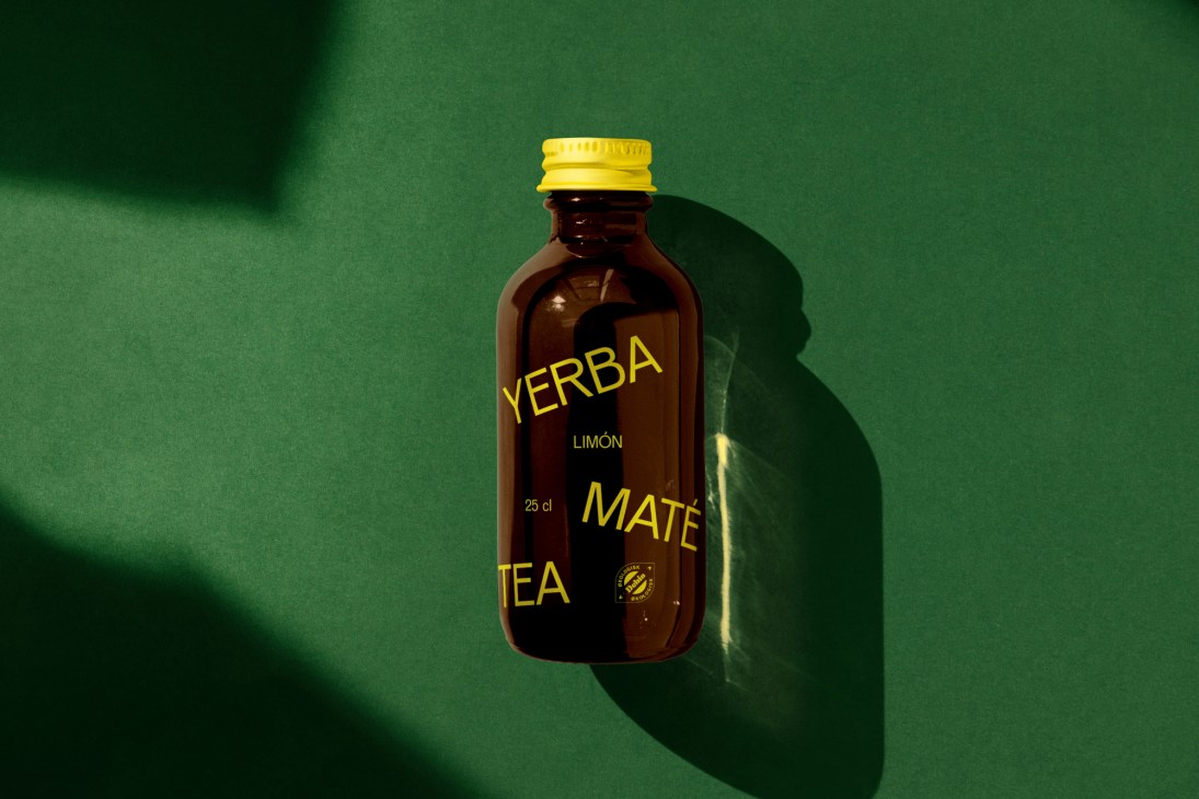 Yerba Limón Maté tea bottle with yellow cap on green background.