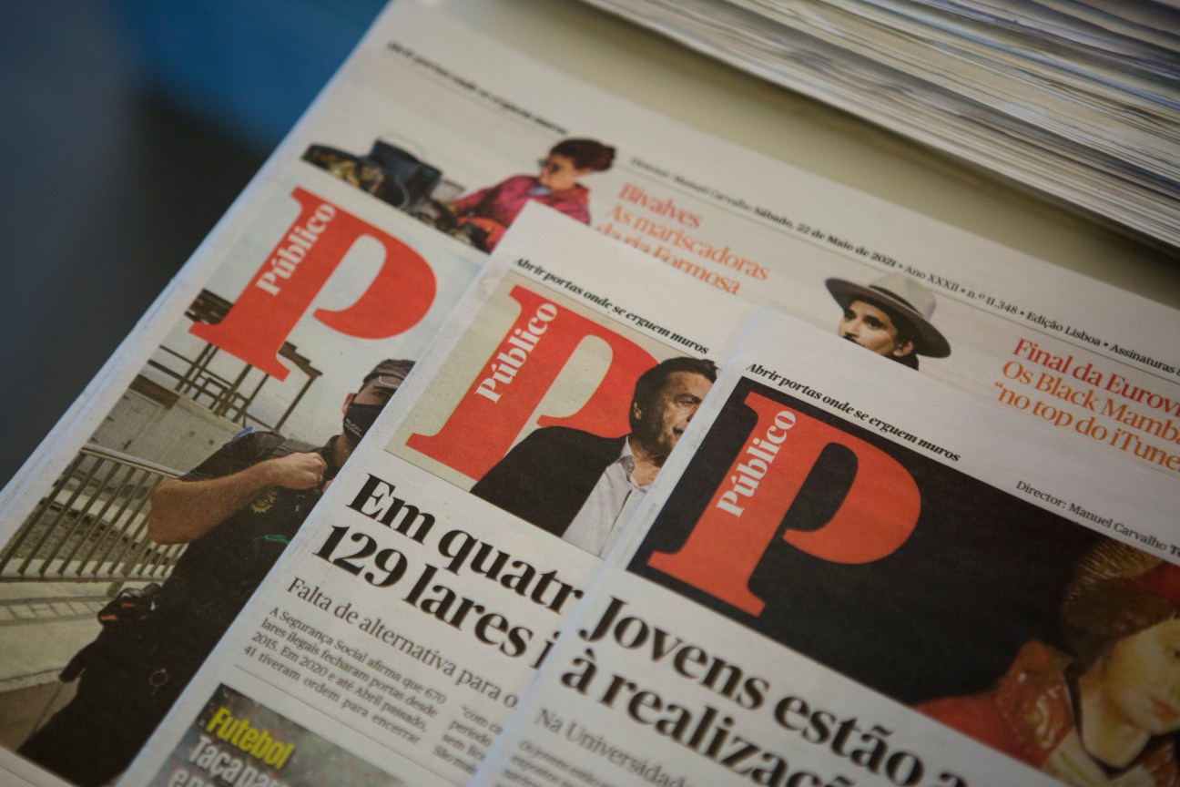 Portuguese newspaper Público displayed with red P logo and Portuguese headlines visible on pages