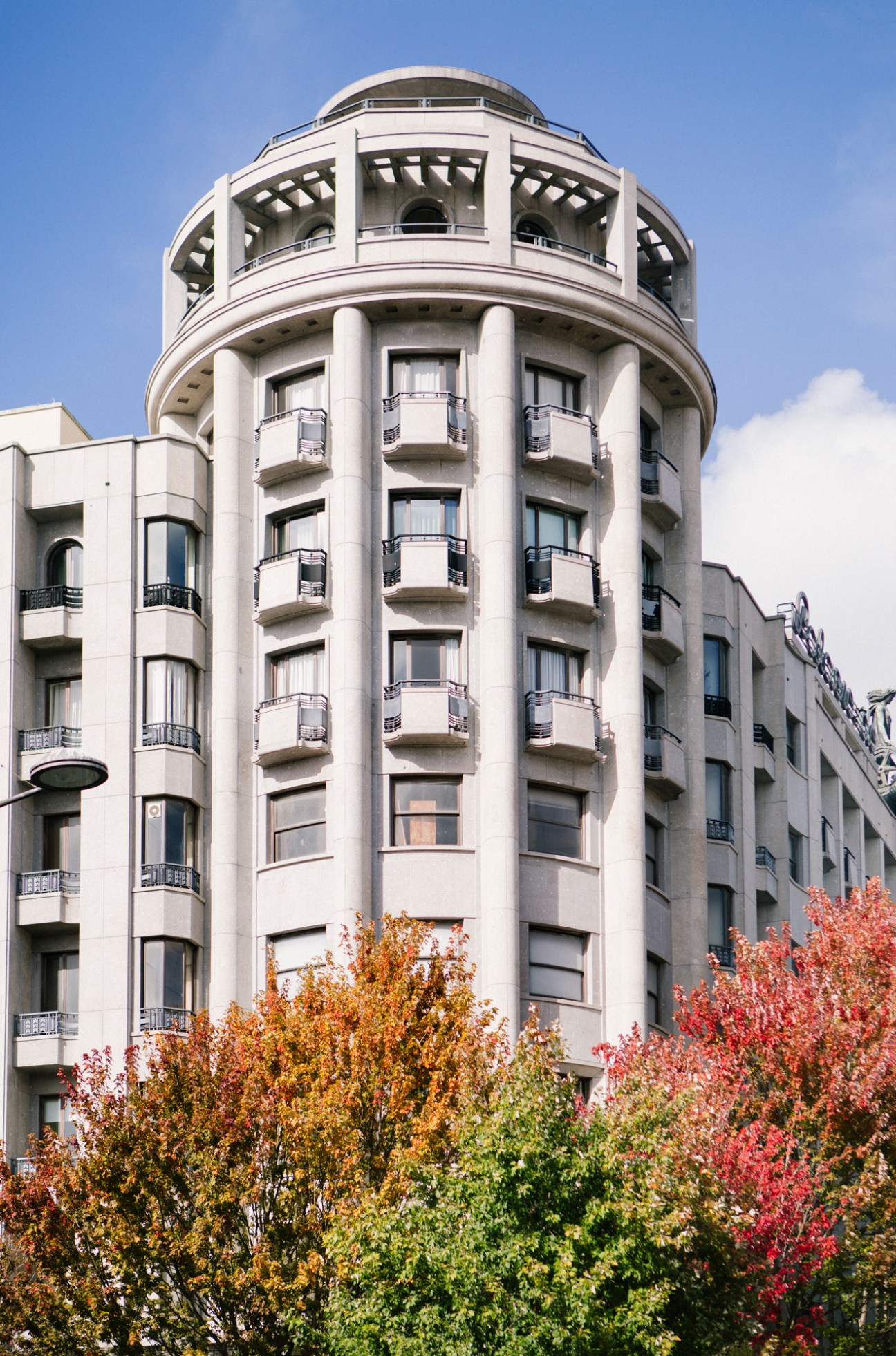 White modernist cylindrical building with curved balconies and domed top in Porto, Portugal.