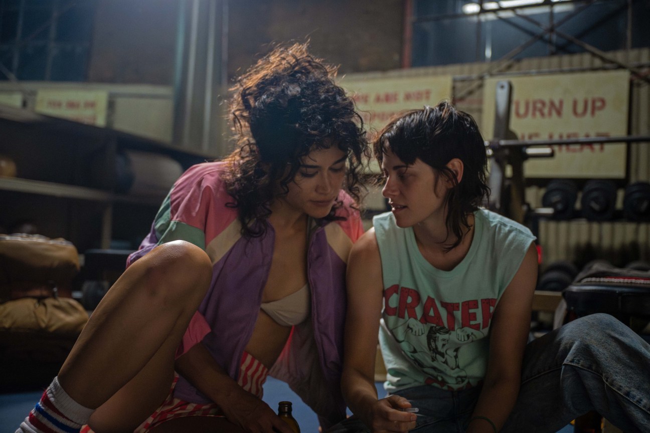 Love lies bleeding film still - two women sitting next to each other closely