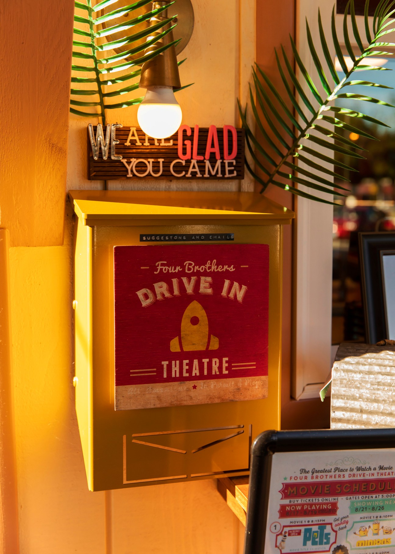 Interior view of Four Brothers drive-in concessions stand with vintage decor, pendant lighting, and palm plants