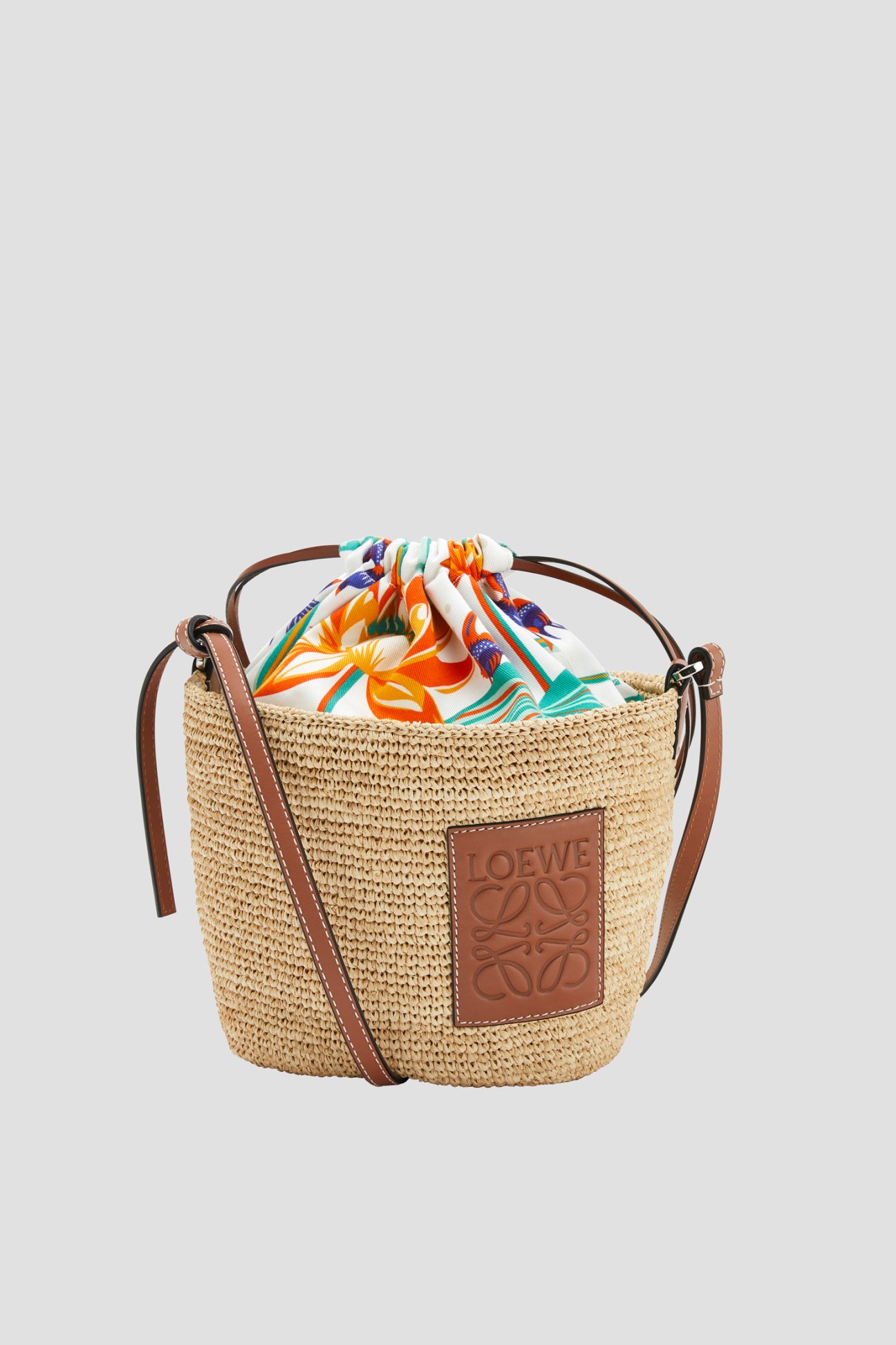 Loewe Paula's Ibiza woven bag with colorful striped fabric drawstring closure and brown leather details.